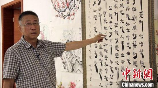 圖為朱群和他的敦煌漢簡(jiǎn)書(shū)體?！「攥?攝