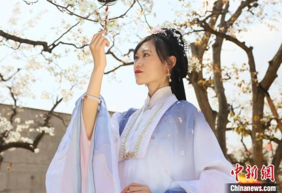 圖為蘭州青年身穿漢服在百年梨園賞景?！「哒?攝