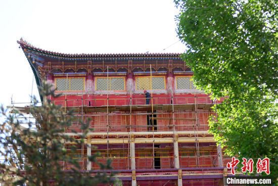 圖為5月上旬，甘肅山丹縣大佛寺內(nèi)，工作人員對(duì)古建筑大雄寶殿進(jìn)行修繕。 中新社記者 高展 攝