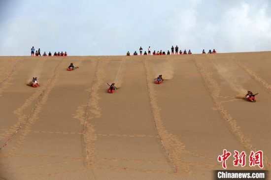 6月13日，敦煌鳴沙山月牙泉景區(qū)舉辦滑沙比賽。　張曉亮 攝