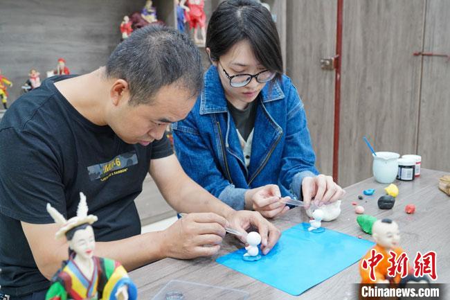 <a target='_blank'  data-cke-saved- >中新社</a>記者(右)現(xiàn)場體驗面塑制作過程?！￡悹帍?qiáng) 攝