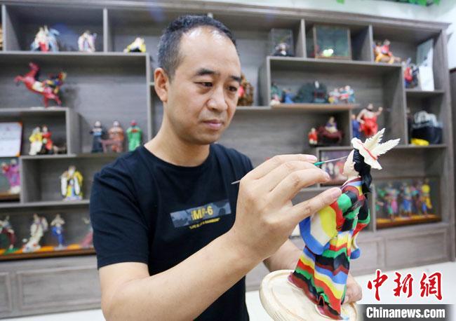 圖為安秋平正在創(chuàng)作代表隴南文縣民俗的《白馬人》作品?！「哒?攝
