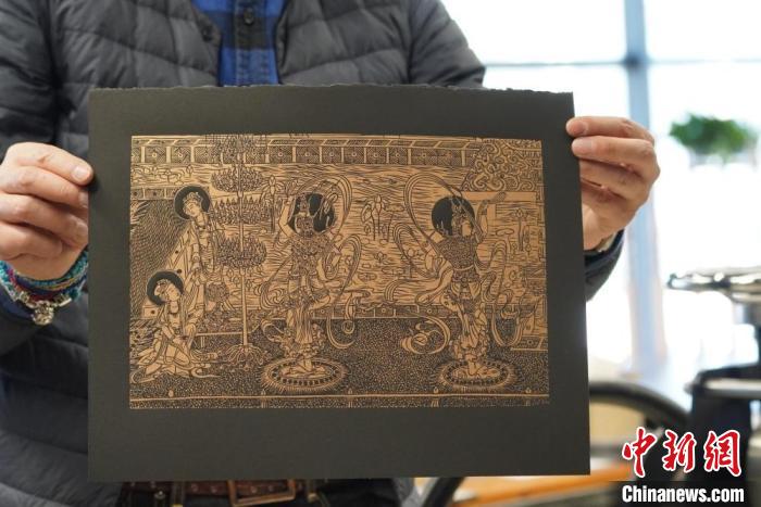 圖為手工書藝人展示敦煌雕版壁畫印刷品。　九美旦增 　攝