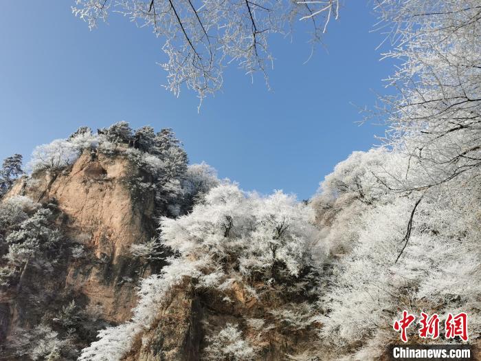 圖為藍(lán)天下霧凇籠罩山脈?！⌒煺袢A 攝