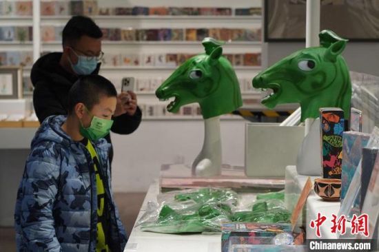 圖為“神馬來了”銅奔馬頭套吸引參觀者駐足?！【琶赖┰?攝