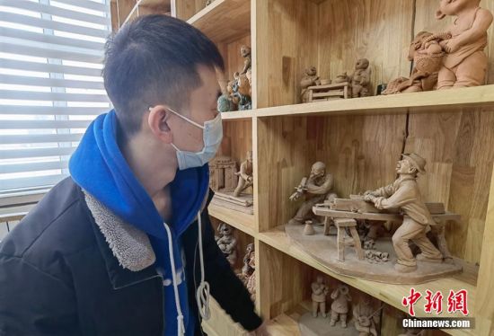 圖為學(xué)生欣賞泥塑作品。 劉玉桃 攝