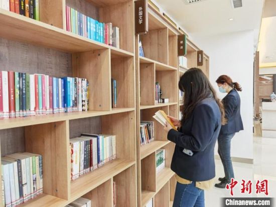 圖為在甘肅公航旅建設(shè)集團(tuán)有限公司的職工書屋，職工挑選書籍。　徐雪 攝