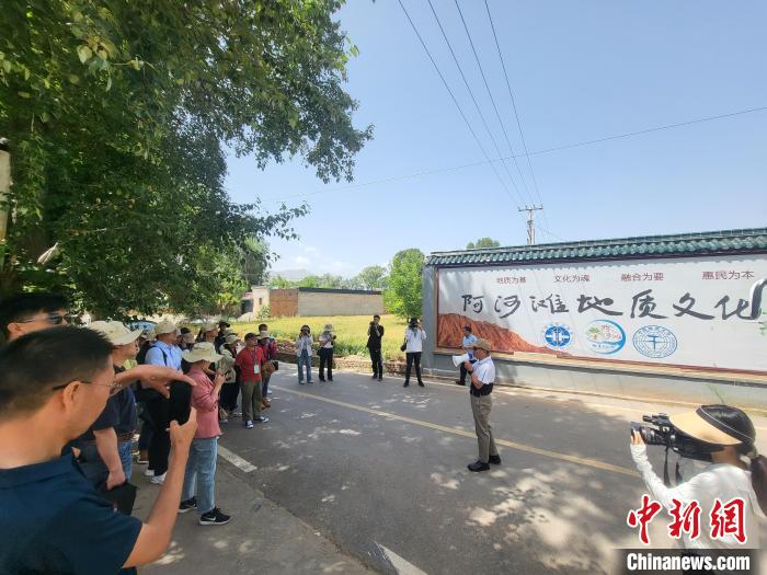 圖為中國地質(zhì)大學(xué)(北京)教授張緒教介紹村落情況?！『衍?攝