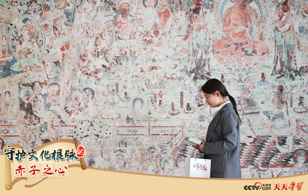 2023年4月25日，敦煌研究院文物數(shù)字化保護(hù)團(tuán)隊(duì)創(chuàng)意營(yíng)銷人員廖雪婷從一幅高保真復(fù)制壁畫前走過(guò)。