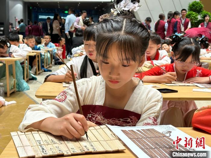 圖為小朋友在甘肅簡牘博物館練習(xí)書法?！≈行律缬浾?戴文昌 攝