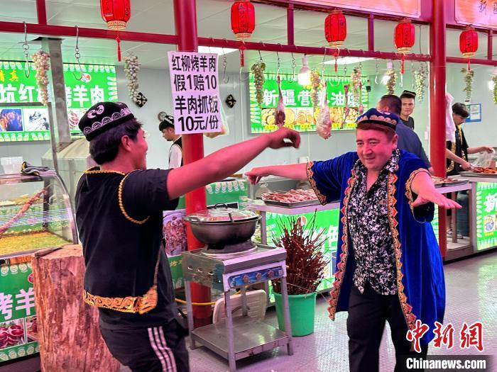 圖為餐飲經(jīng)營者在“西涼不夜城”跳起舞蹈引客?！〈魑牟?攝</p><p>