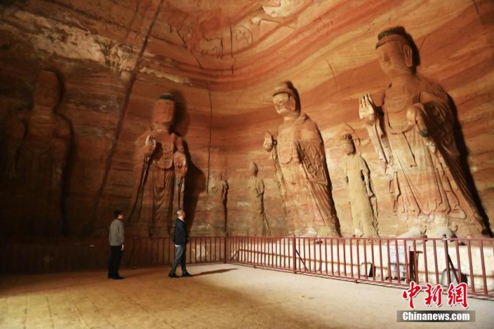 7月15日，游人參觀甘肅省平?jīng)鍪袥艽h百里石窟長廊中的南石窟寺1號(hào)窟。百里石窟長廊位于涇川縣境內(nèi)，由512個(gè)石窟、5眼窟中石井組成，現(xiàn)存王母宮石窟、鳳凰山石窟、南石窟寺、丈八寺石窟、羅漢洞石窟、太山寺石窟等規(guī)模較大的石窟群，還有數(shù)量眾多的小石窟群。南石窟寺開鑿于北魏永平三年，其中1號(hào)窟屬于大型七佛窟，七佛高達(dá)6米。中新社記者 李亞龍 攝